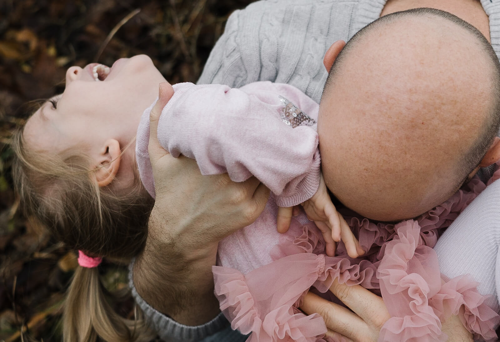 Papa kitzelt seine Tochter am Bauch