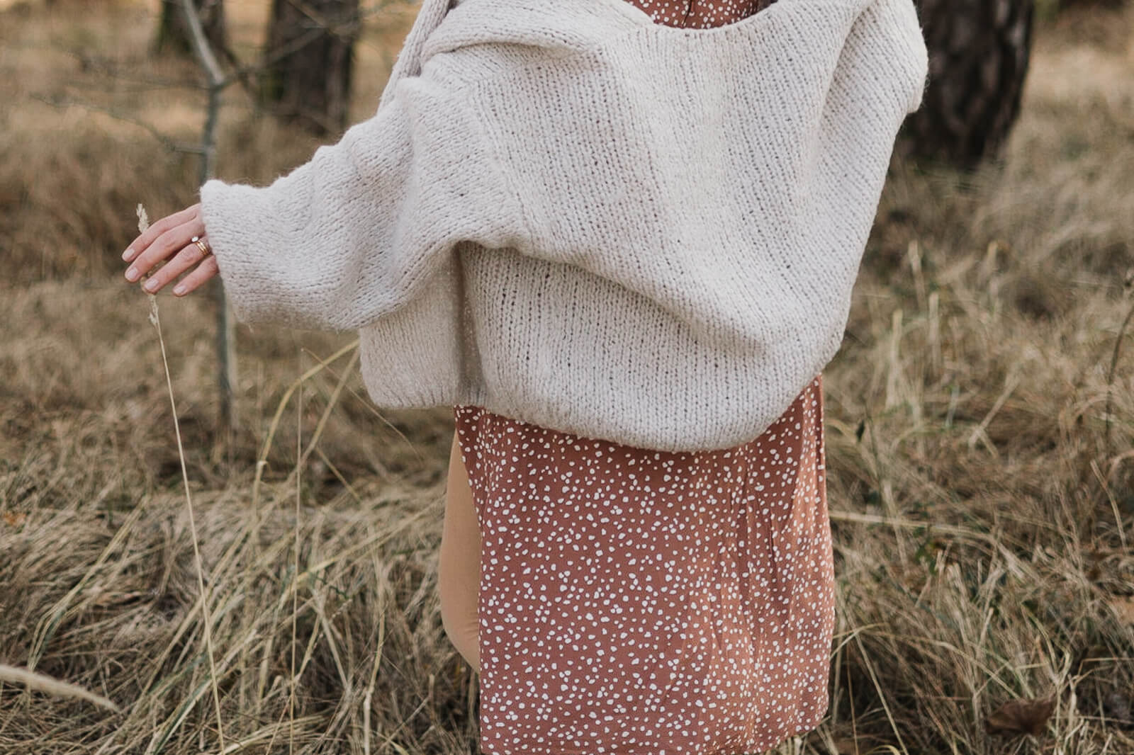 Eine schwangere Frau läuft durch das hohe Gras der Münchner Heide