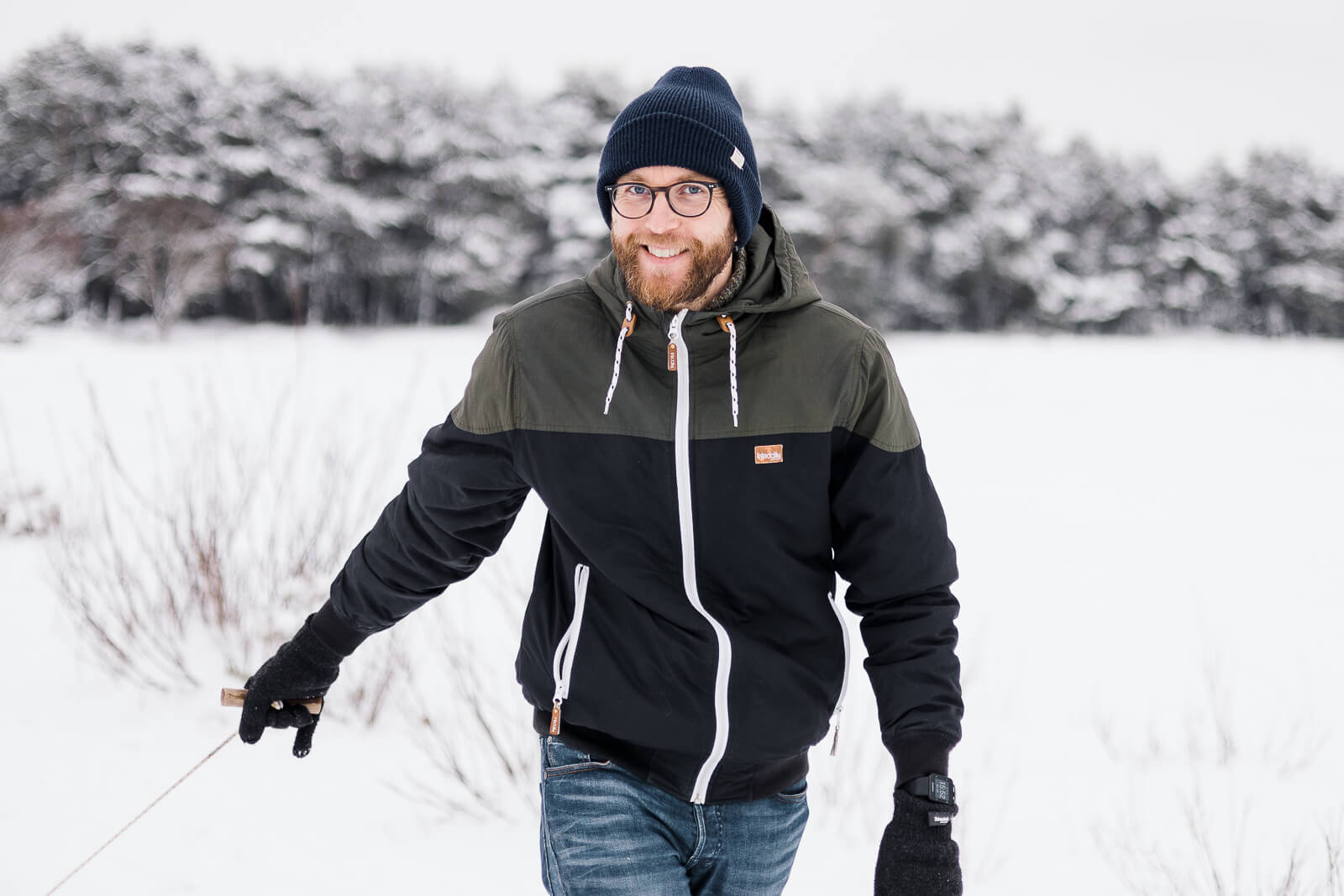 Ein Familienvater zieht im Schnee einen Schlitten