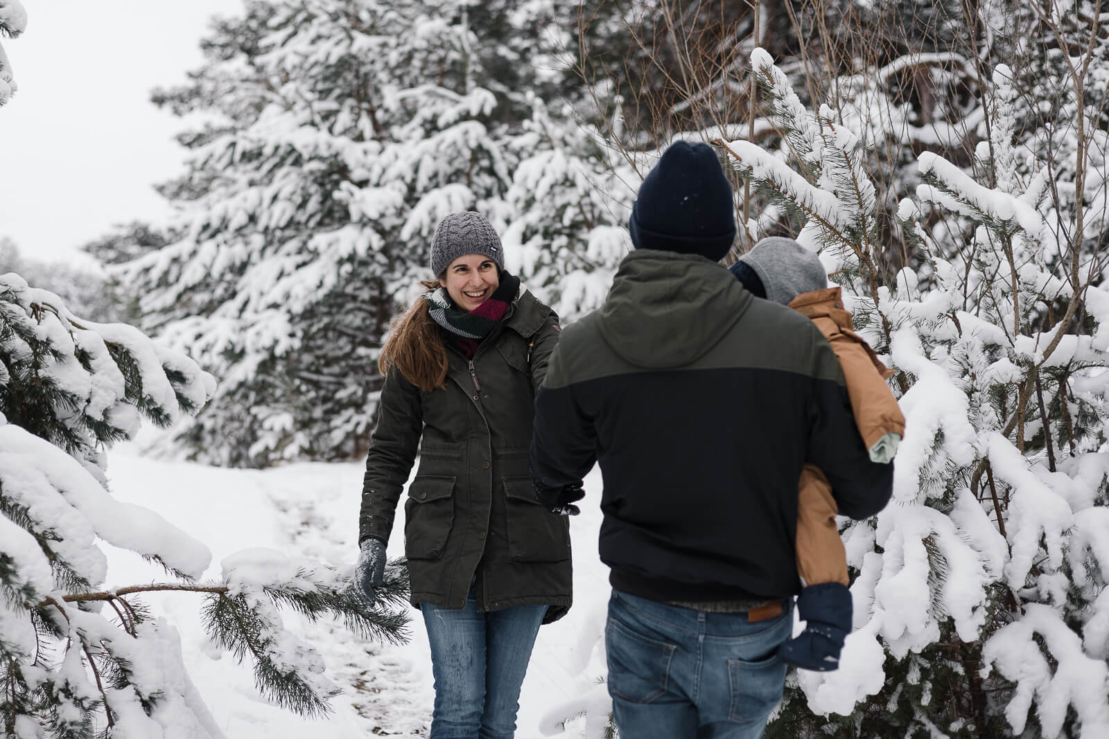 Eine kleine Familie läuft durch den verschneiten Winterwald