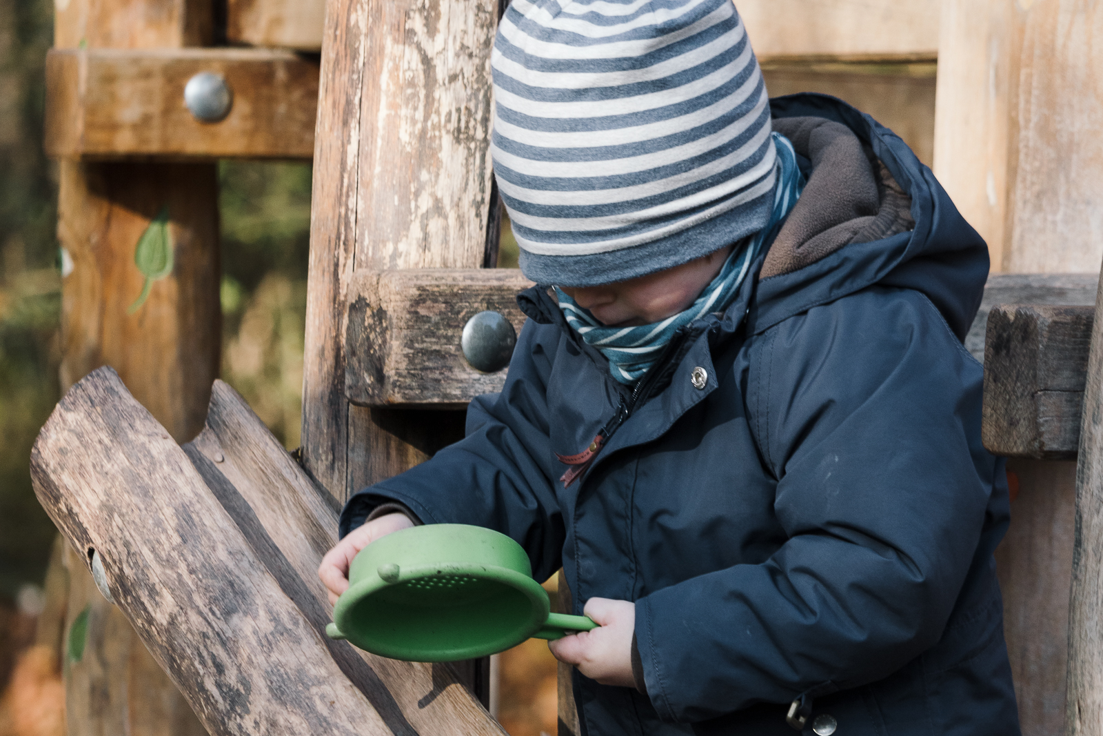 Ein kleiner Junge spielt auf einem Spielplatz mit Sandspielsachen