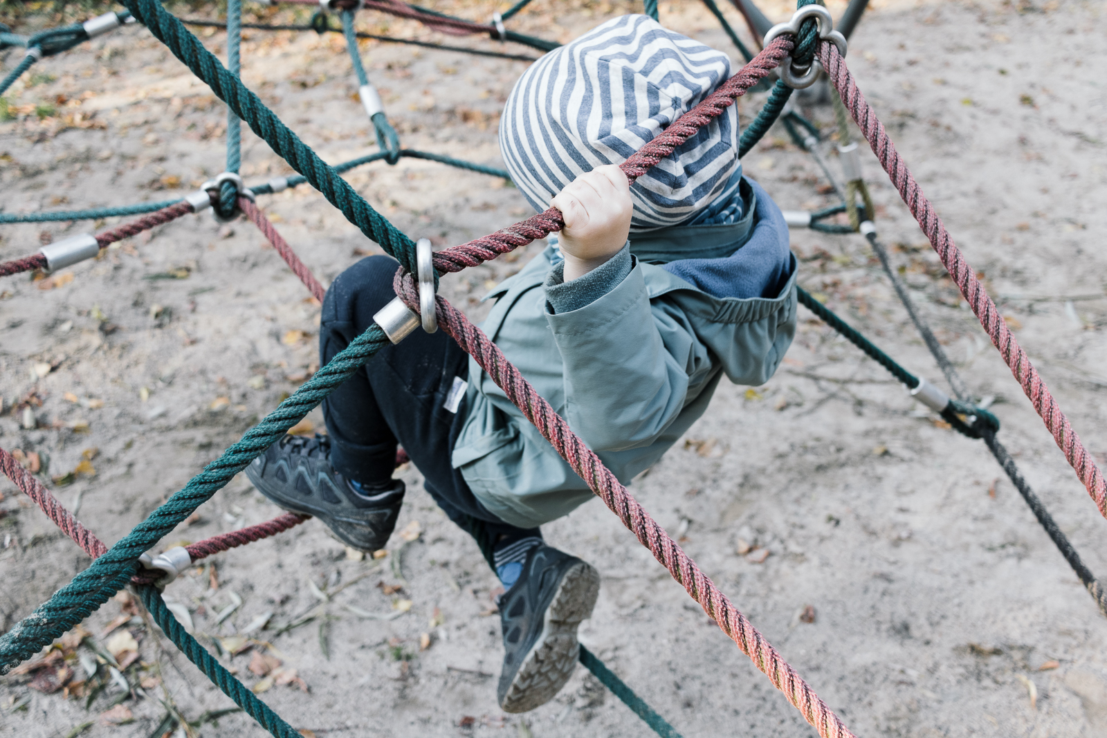 Ein mutiger Junge klettert auf einem Spielplatz
