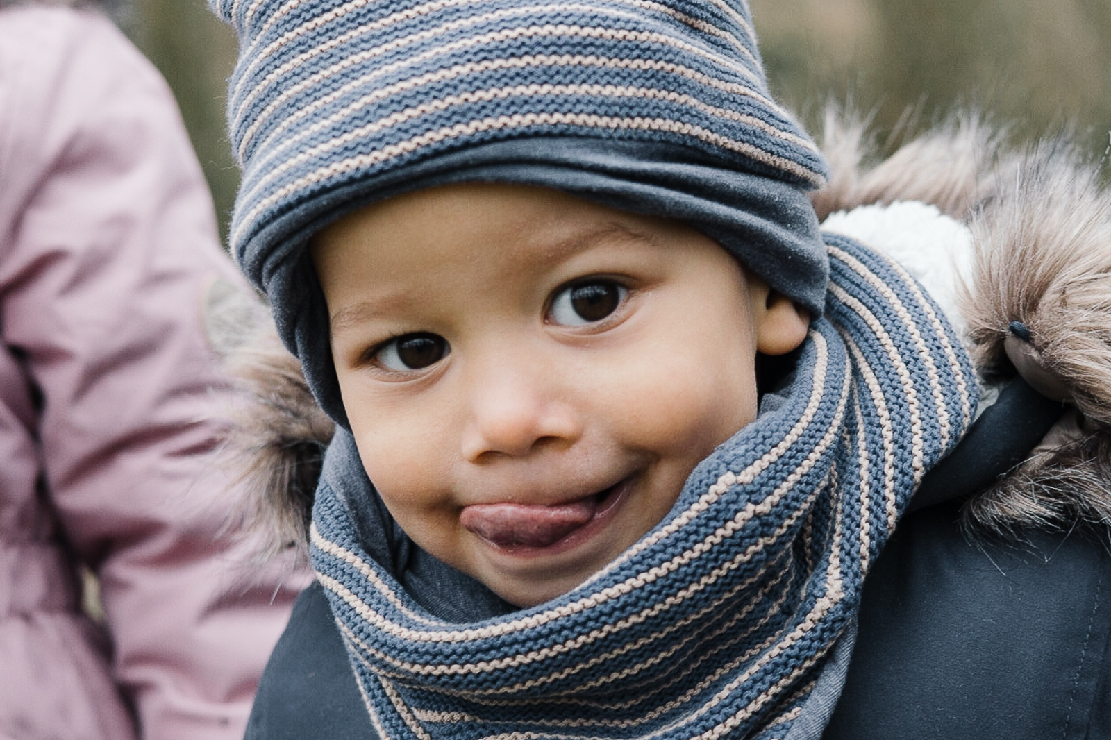 Ein kleiner Junge schaut verschmitzt in die Kamera und lächelt